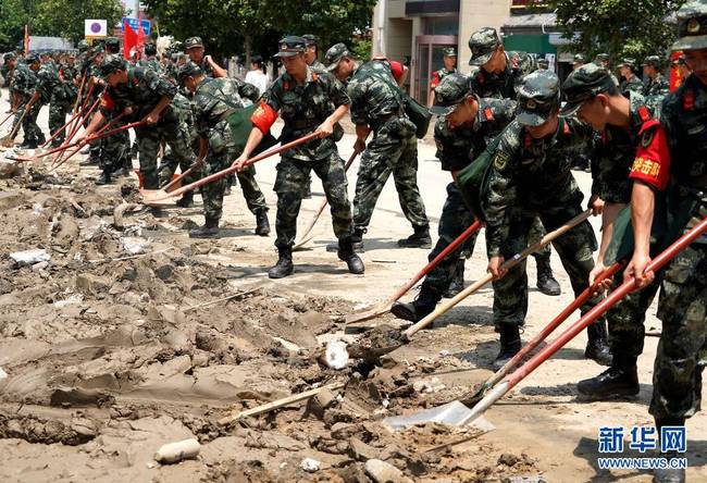 7月25日，救援人员在郑州市中牟县进行路面清淤作业。